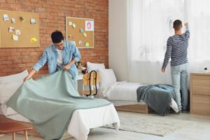 two young men setting up their college dorm room